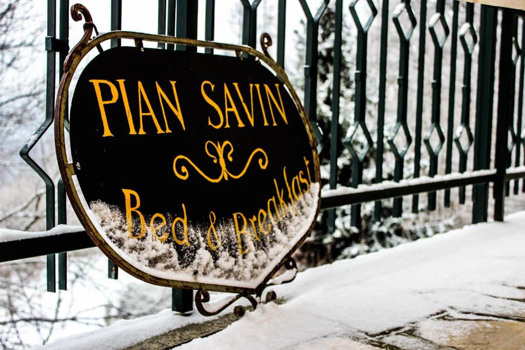a sign on a fence with snow on it at B&B Pian Savin in Giaveno