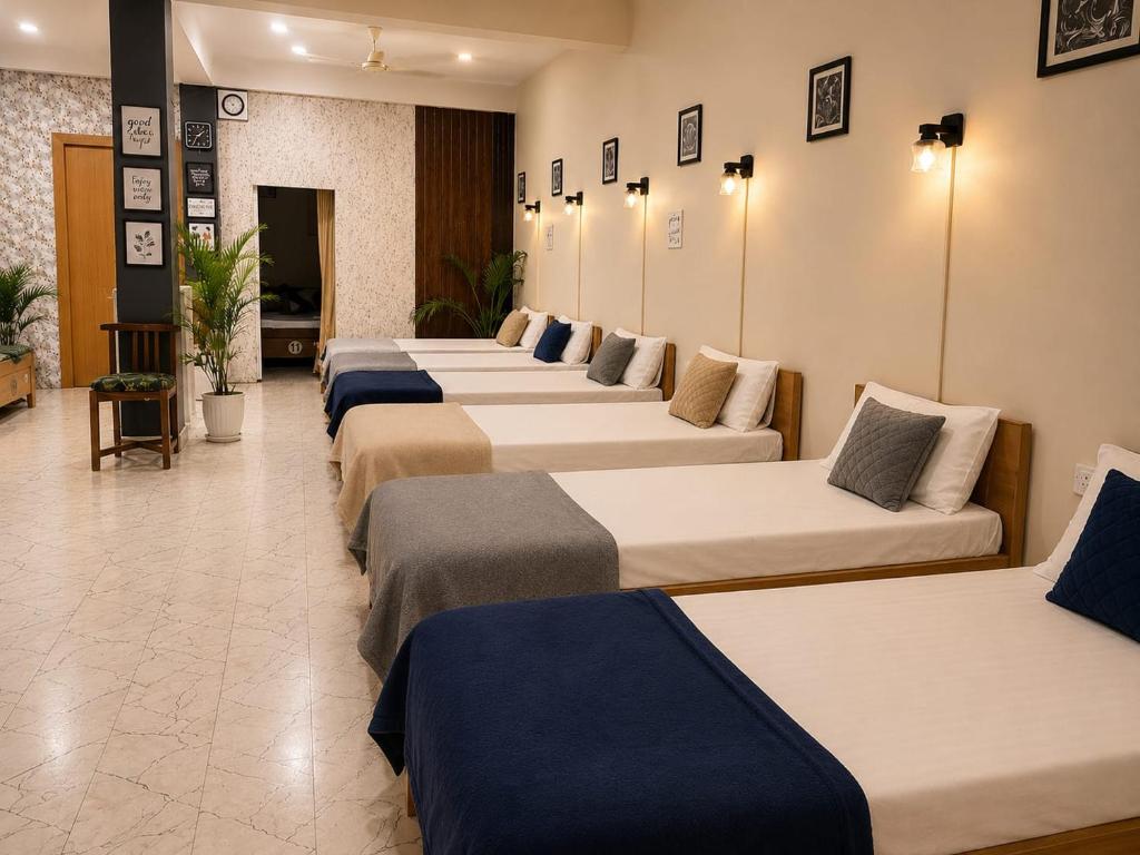 a row of beds lined up in a room at Rahat Dormitory in Jāmb