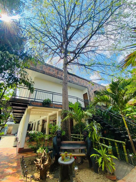 a building with a tree in front of it at Hotel Colonial Sol y Luna in Paz de Ariporo