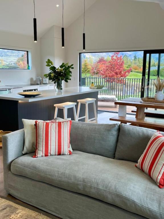 a living room with a couch and a kitchen at Luxury Mountain View Retreat in Frankton