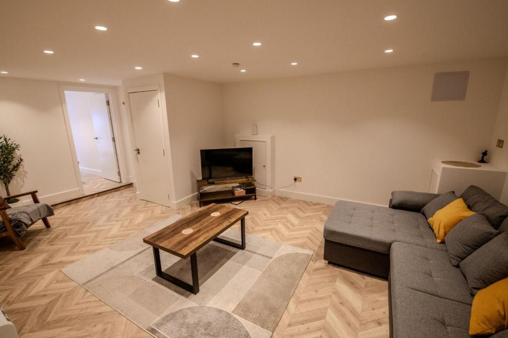 a living room with a couch and a tv at Rye Hideaway with Hot Tub - Rye in Rye
