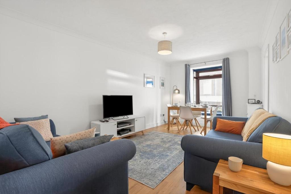 a living room with two blue couches and a tv at 2 Bed in Swanage oc-wy547 in Swanage