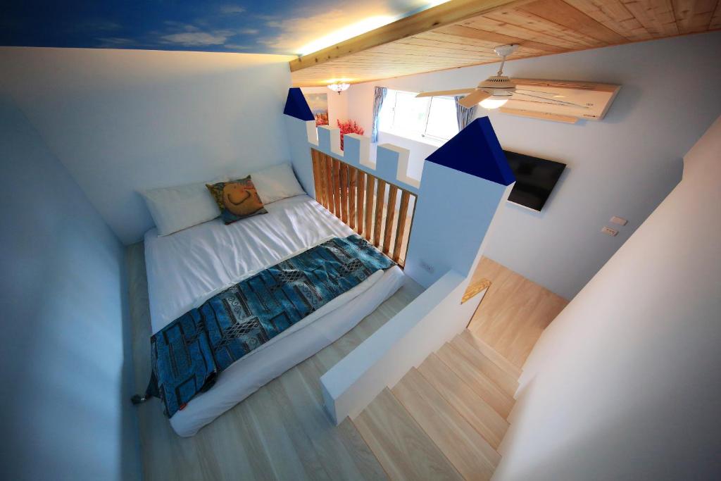 una piccola camera con un letto e una televisione di 跳跳民宿 包棟首選 a Xiaoliuqiu