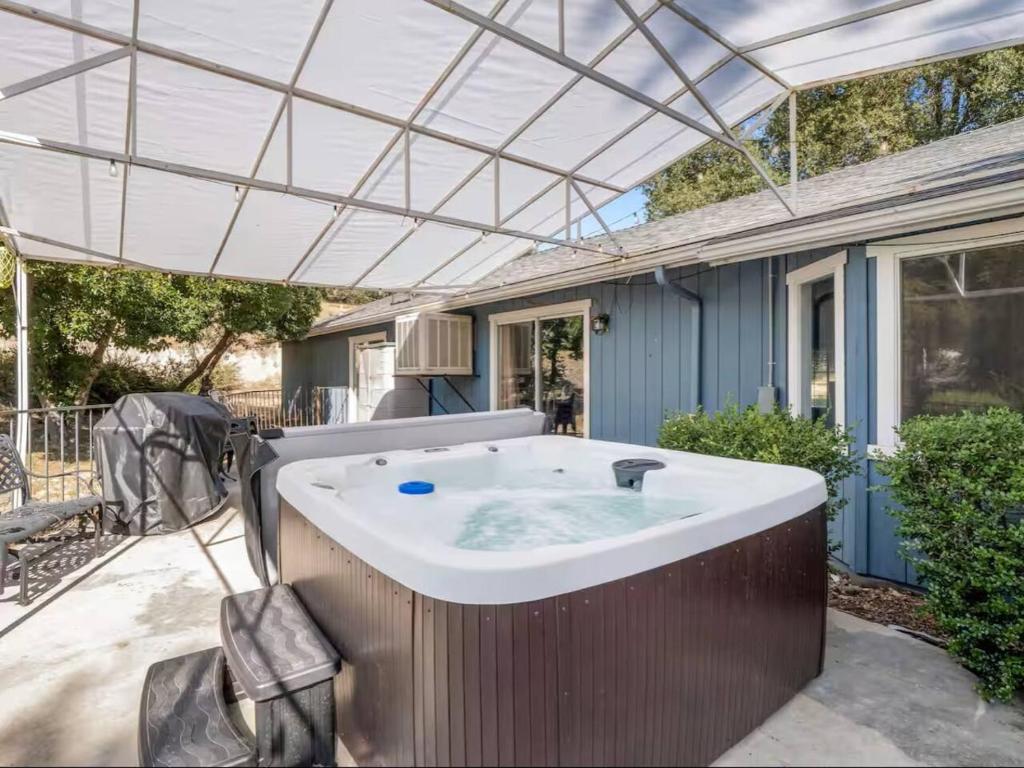 a hot tub under a pergola on a patio at Meadowlark Retreat in Ahwahnee