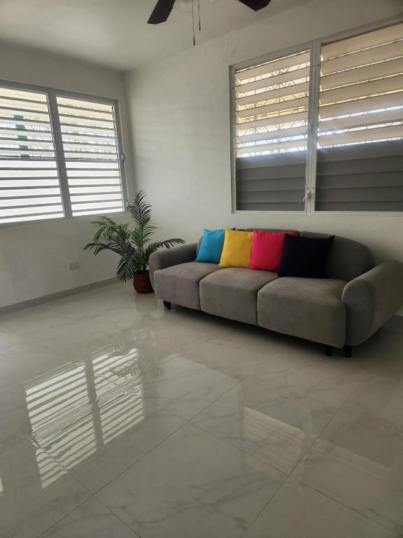 a living room with a couch with colorful pillows at 2BR Apartment, Blue Ocean Suites, Manati in Manati
