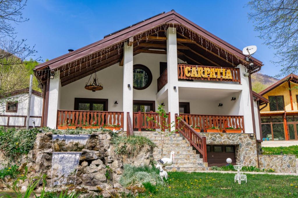 a house with a large porch and a balcony at Carpatia Retezat in Clopotiva