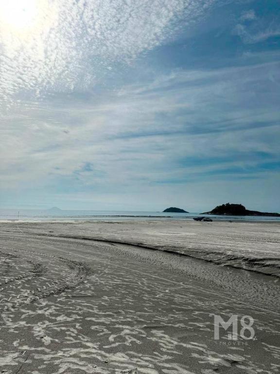 an empty beach with footprints in the sand at Cantinho do Mar in Bertioga