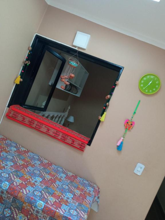 a mirror hanging on a wall next to a bed at La Chili in Salta