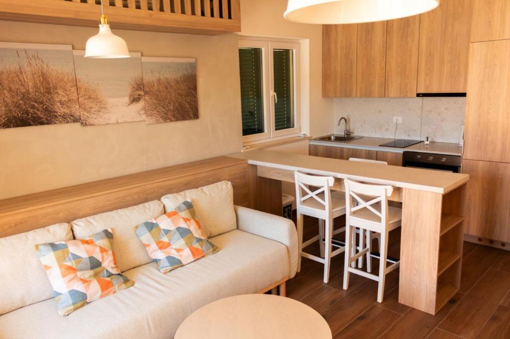 a living room with a couch and a kitchen at Apartment Solis 6 in Stara Novalja