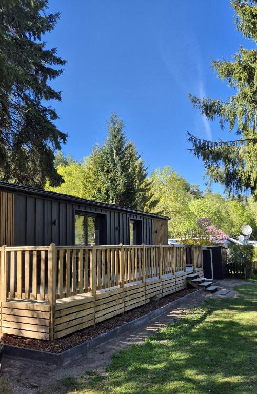 a wooden fence in front of a house at Ferienhaus mit eigenem Boot & 2 Fahrrädern ca 100 m zum See An den Sieben Seen in Lohmen