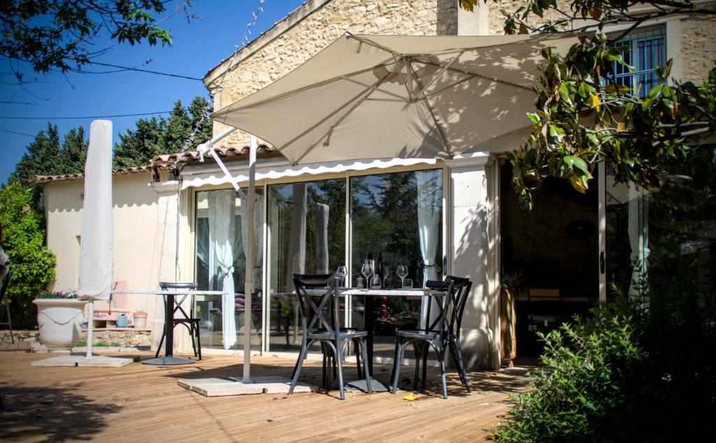 a patio with a table and chairs under an umbrella at Domaine de la violette in Orange