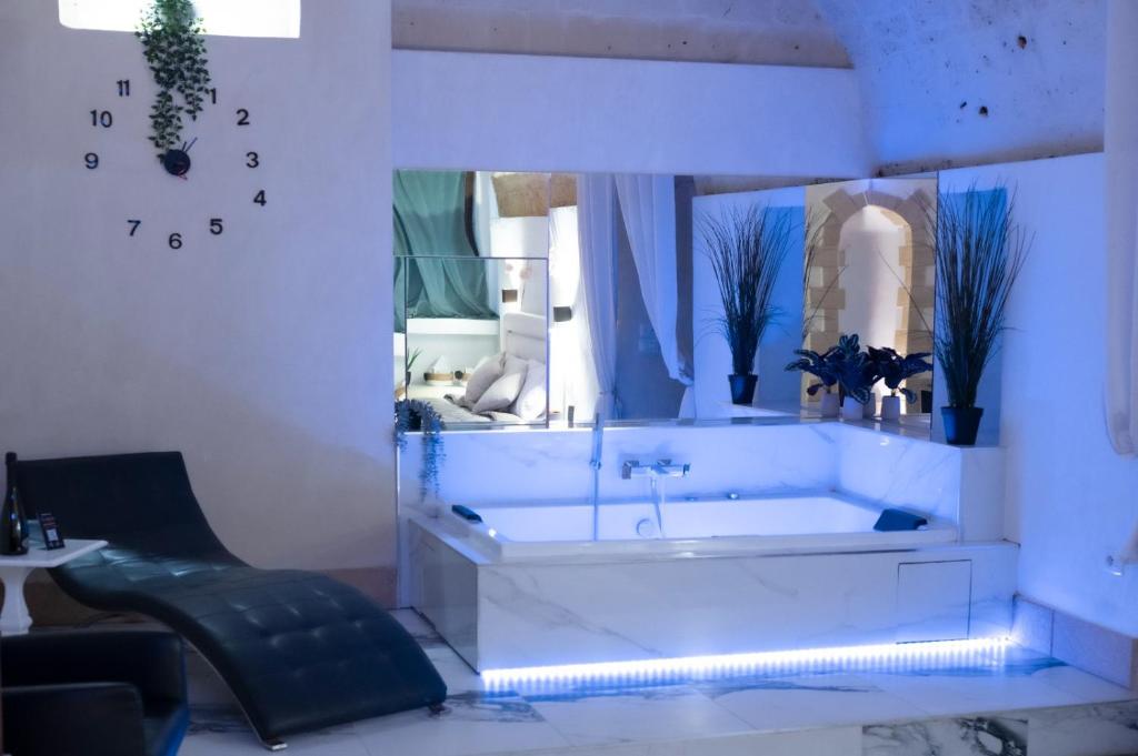 ein Badezimmer mit Badewanne, Spiegel und Stuhl in der Unterkunft QUART0 GREC0 Suite 15 in Altamura