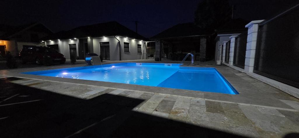 a blue swimming pool in a yard at night at Djurdjevik Home in Živinice
