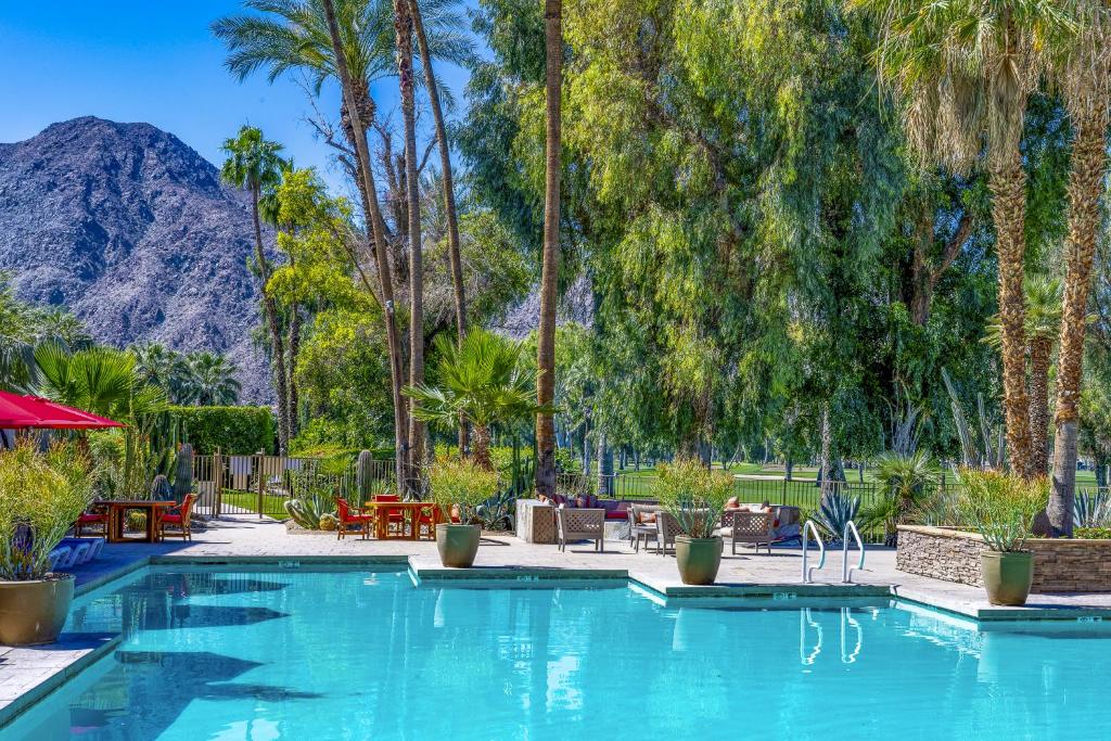 a swimming pool with palm trees and a mountain in the background at Indian Wells Resort Hotel in Indian Wells