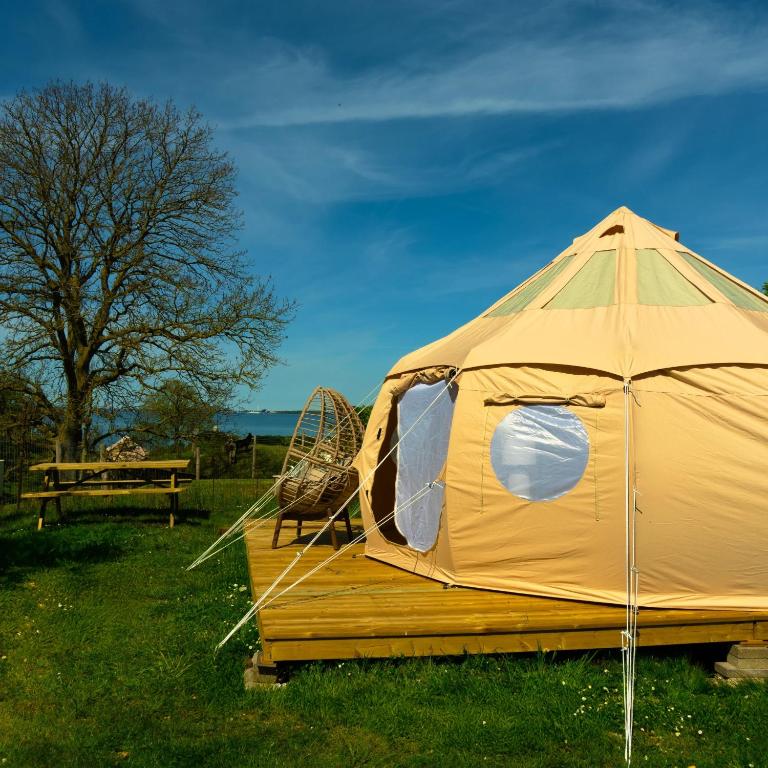 a tent sitting in the grass with a swing at Fyn Glamping in Nyborg