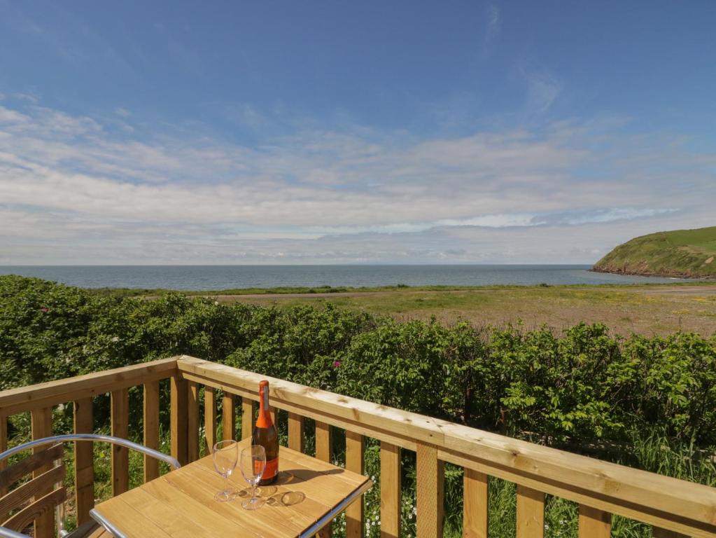 a bottle of wine sitting on a table on a balcony at The Swift in St Bees