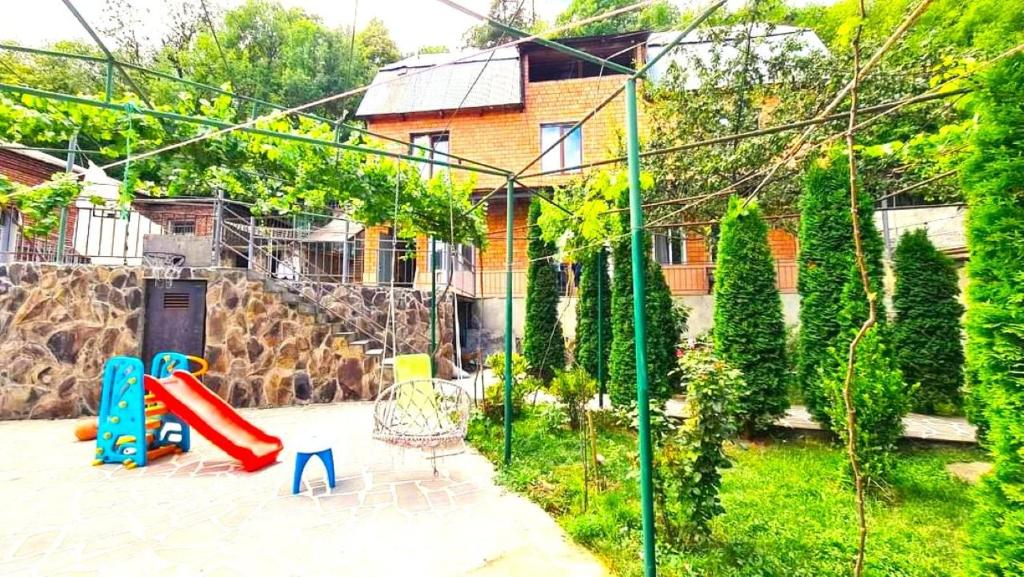a playground in front of a house with a slide at Cozy Corner in Borjomi