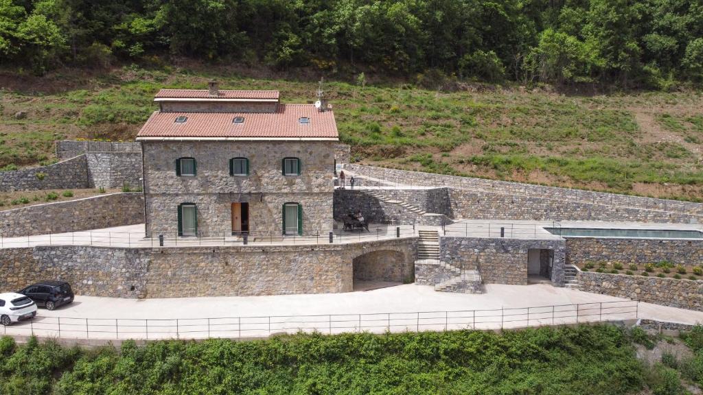 a stone building with a car parked in front of it at Villa Eremo Cinque Terre in Castiglione Chiavarese