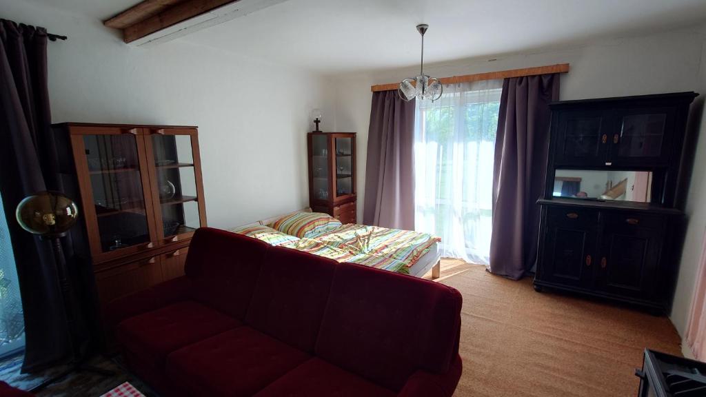 a living room with a couch and a large window at Dům in Hrabowa