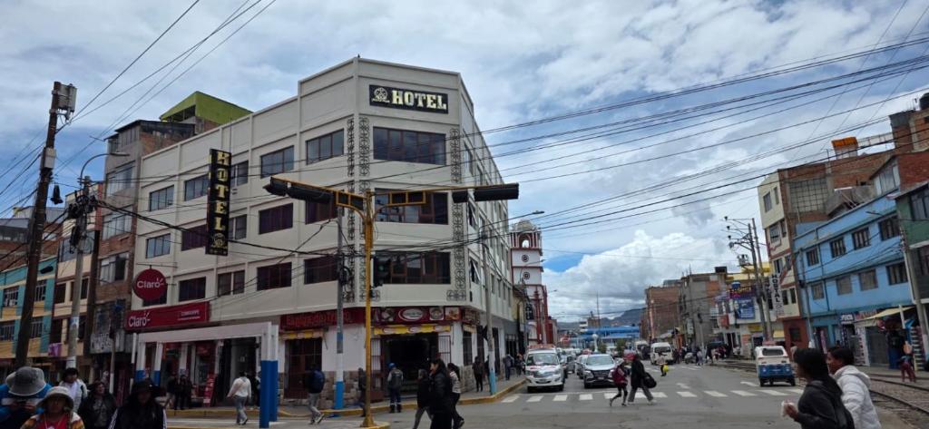 a building on a city street with people crossing the street at Hatun Wasi Puno in Puno
