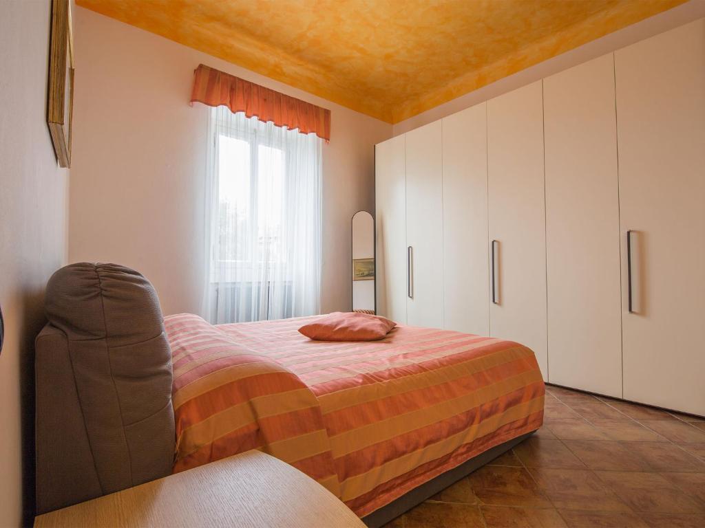 ベッラージョにあるMella Bellagio Rosa Dei Venti - Elegante appartamento nel cuore di Bellagio con parcheggio privatoのベッドルーム1室(ベッド1台、椅子付)