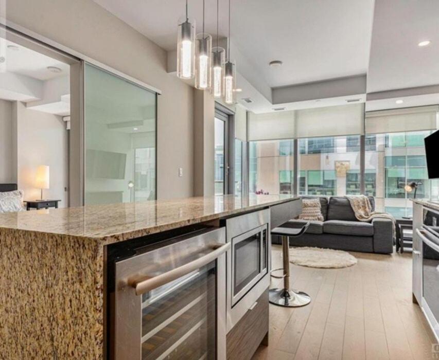 a kitchen with a large island in a living room at Executive Condo with Parking DT Ottawa in Ottawa
