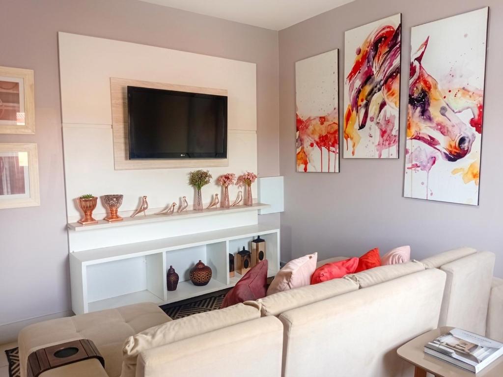 a living room with a couch and a tv at Refúgio Urbano Amplo e Luxuoso in Imperatriz