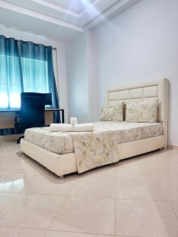 a bedroom with a large bed and a piano at Rmilate Coast Apartment in Asilah