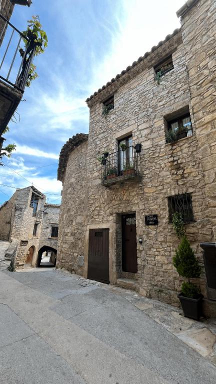 an old stone building with a door and a balcony at CAN PINÓS de GUIMERÀ in Guimerá