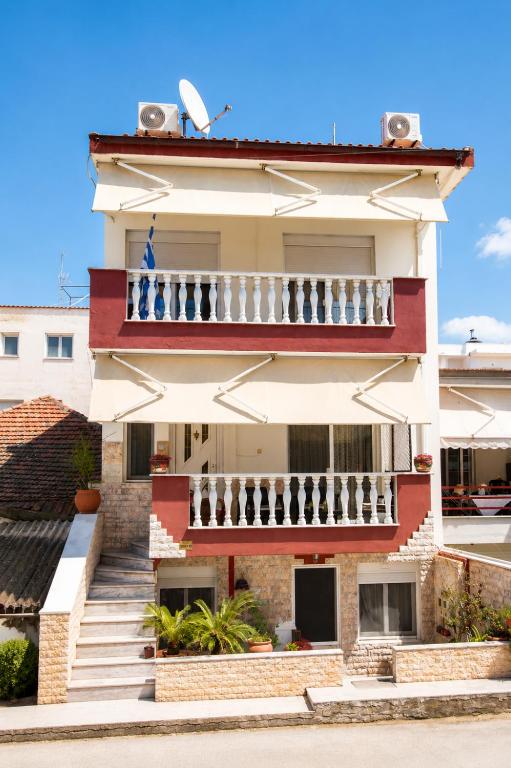 a building with a balcony on the side of it at Villa George in Nea Peramos