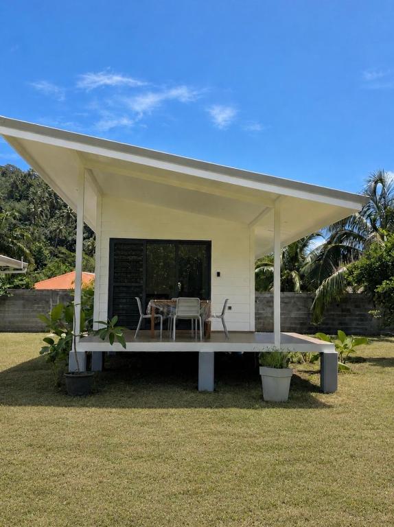 a white pavilion with a table and chairs in a yard at Au Petit Bungalow - Air conditionned & Mountain view in Moorea