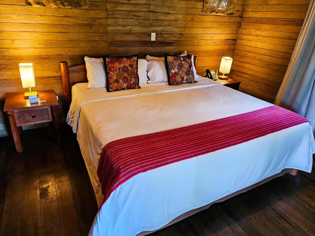 a bedroom with a large bed with wooden walls at Hotel Argovia Centro Wellness in Tapachula