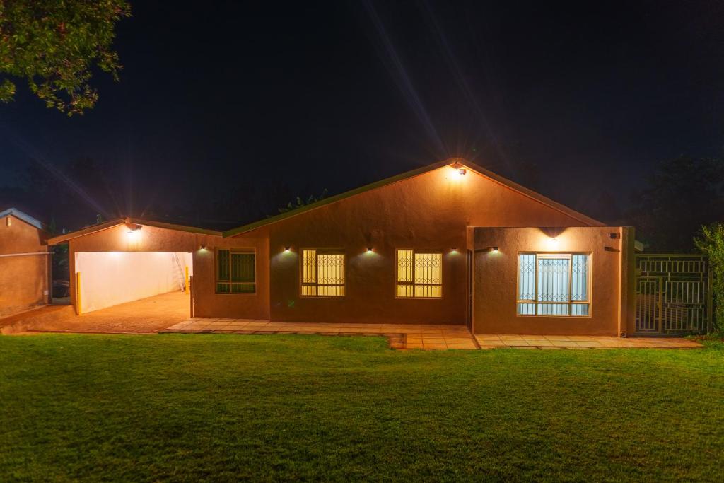 a house with lights on the side of it at night at Faraja House in Maragoli