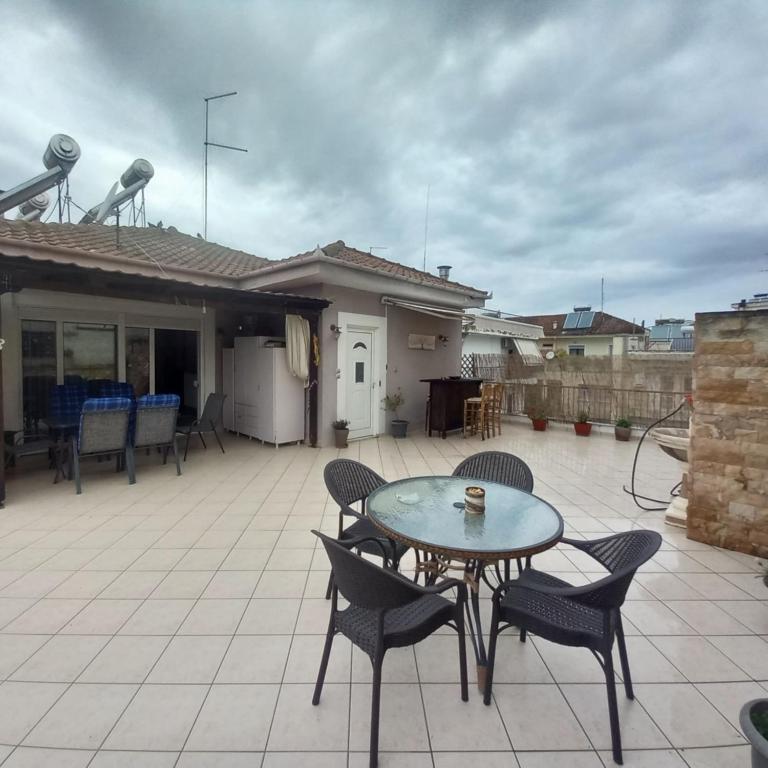 a patio with a table and chairs on a roof at Evi's balcony in Karditsa