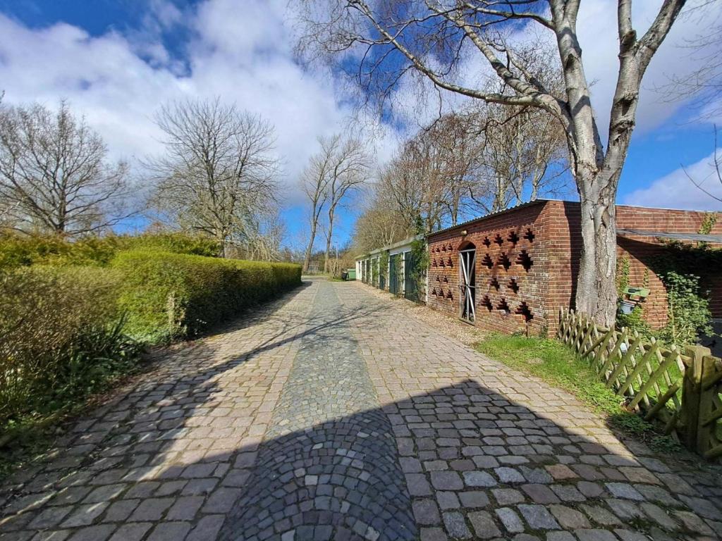 a brick road with a tree and a brick building at Landhaus Gerdts - 5 in Cuxhaven