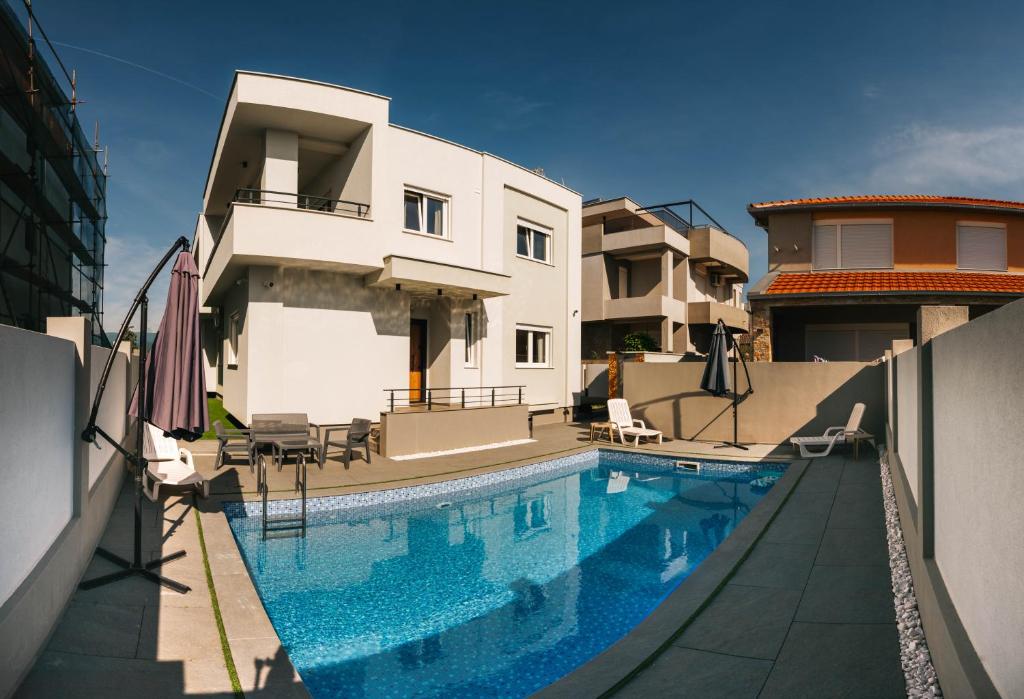 a swimming pool in front of a house at Apartments BUBBLES with pool in Gevgelija