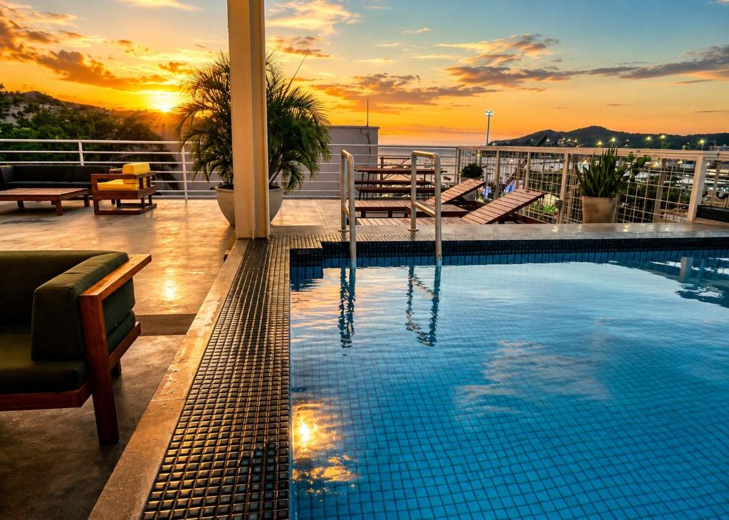 a pool on the roof of a building with the sunset at MuchoSur Santa Marta in Santa Marta