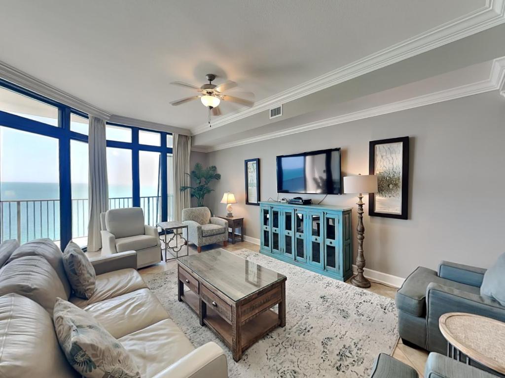 a living room with a couch and a tv at The Oasis Orange Beach 2110 in Orange Beach