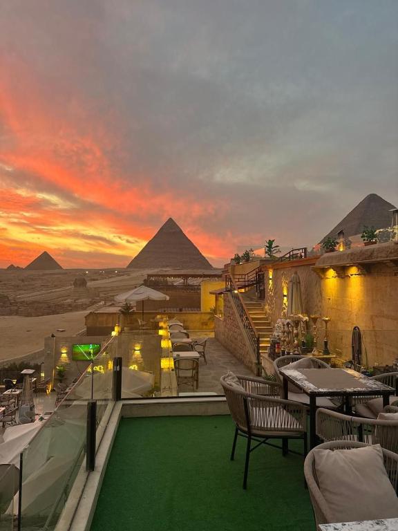 a resort with a view of the pyramids at sunset at Hermes On The Spot Pyramids Hotel in Cairo
