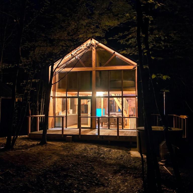 a glass house in a forest at night at Secret Sanctuary in Brad