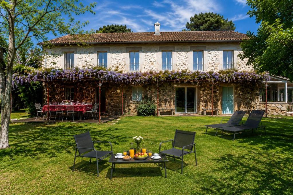 a house with chairs and a table in the yard at Villa Baños in Caldelas