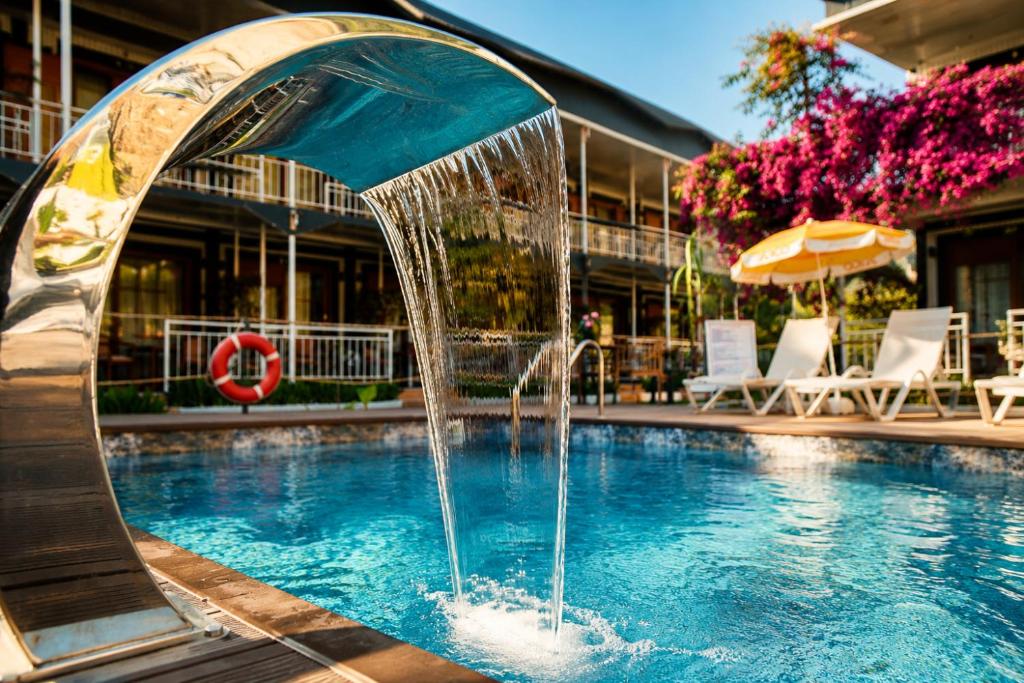 a fountain in the middle of a swimming pool at Fii Suites in Kumluca