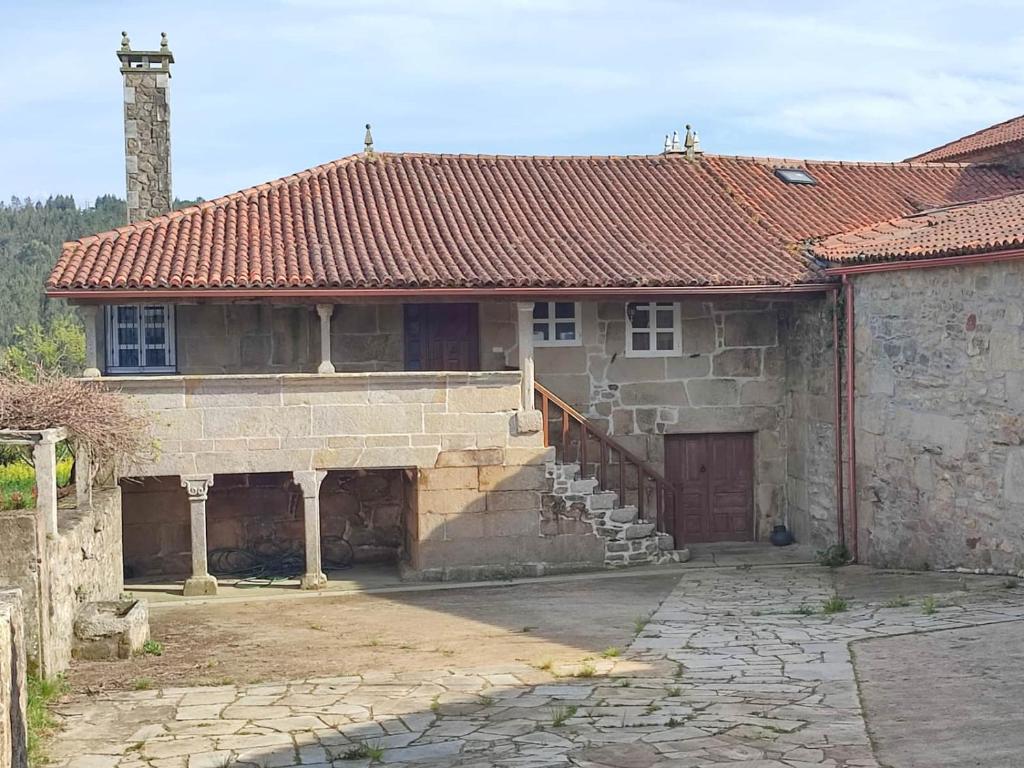 an old stone house with a staircase in front of it at Casa da Torreira Naturaleza y descanso in Galegos