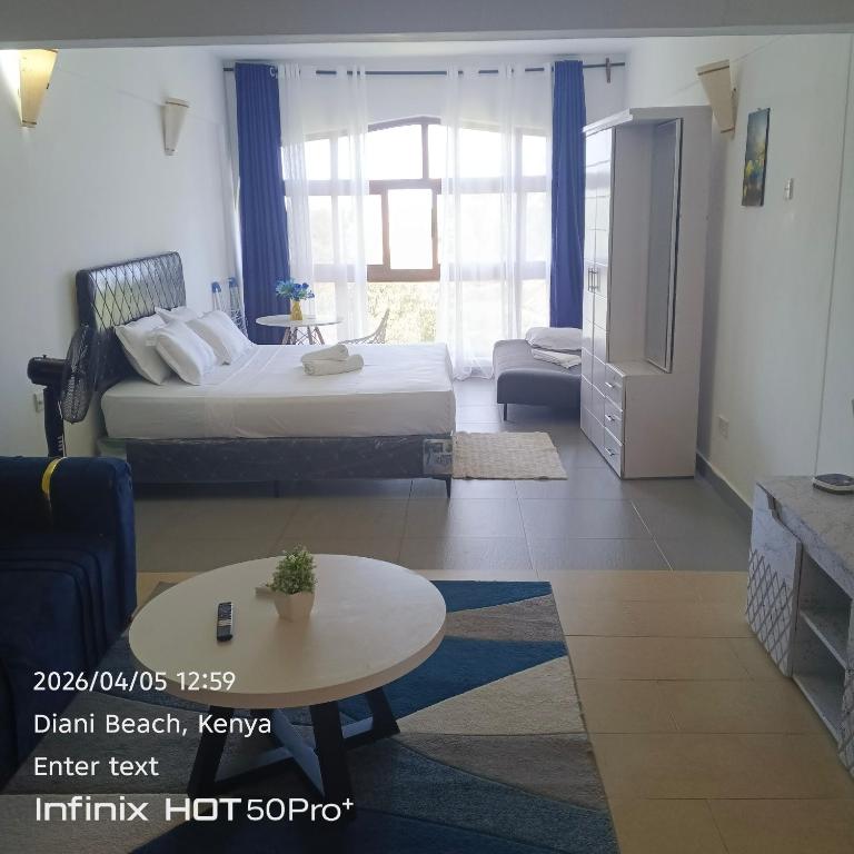 a bedroom with a bed and a living room at See breeze sweets villa in Diani Beach