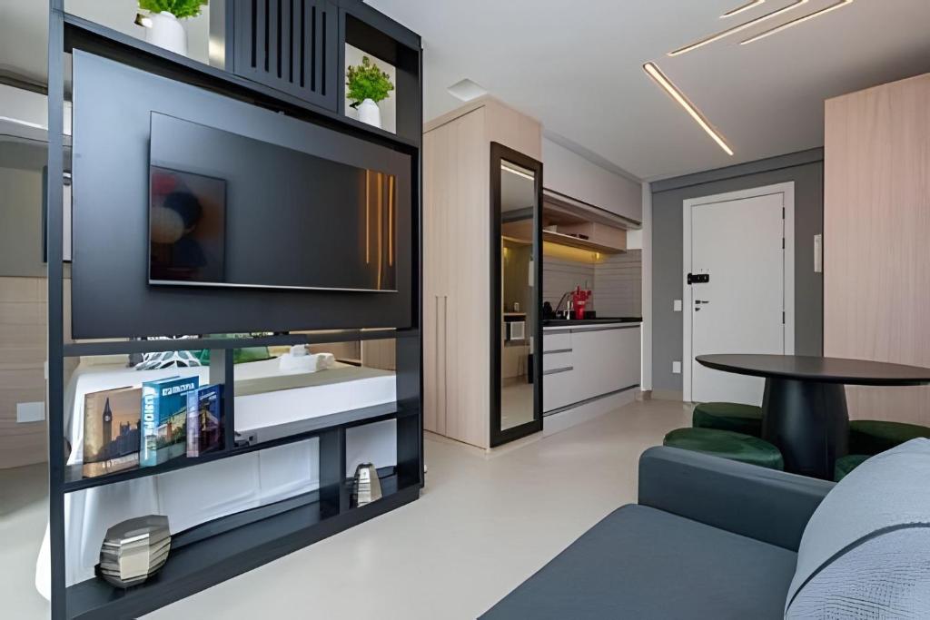 a living room with a tv on a wall at Estadia Sampa Butantã in São Paulo