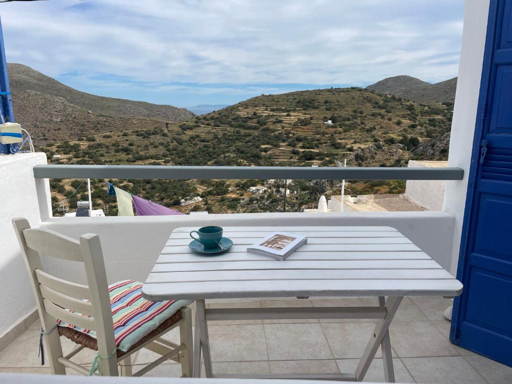 a table and chair on a balcony with a view at Vorino house in Amorgos