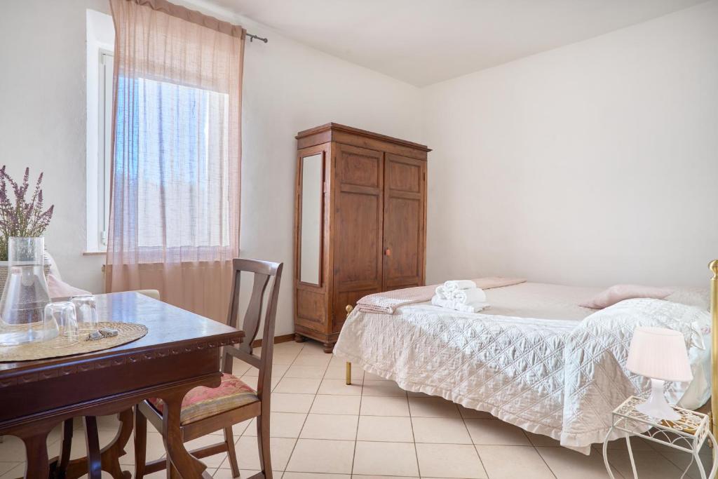 a bedroom with a bed and a desk and a table at Agriturismo Le grondaie in Siena
