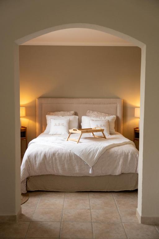 a bedroom with a large bed with white sheets and pillows at Le Castelas - Suite Calisson in Aurons