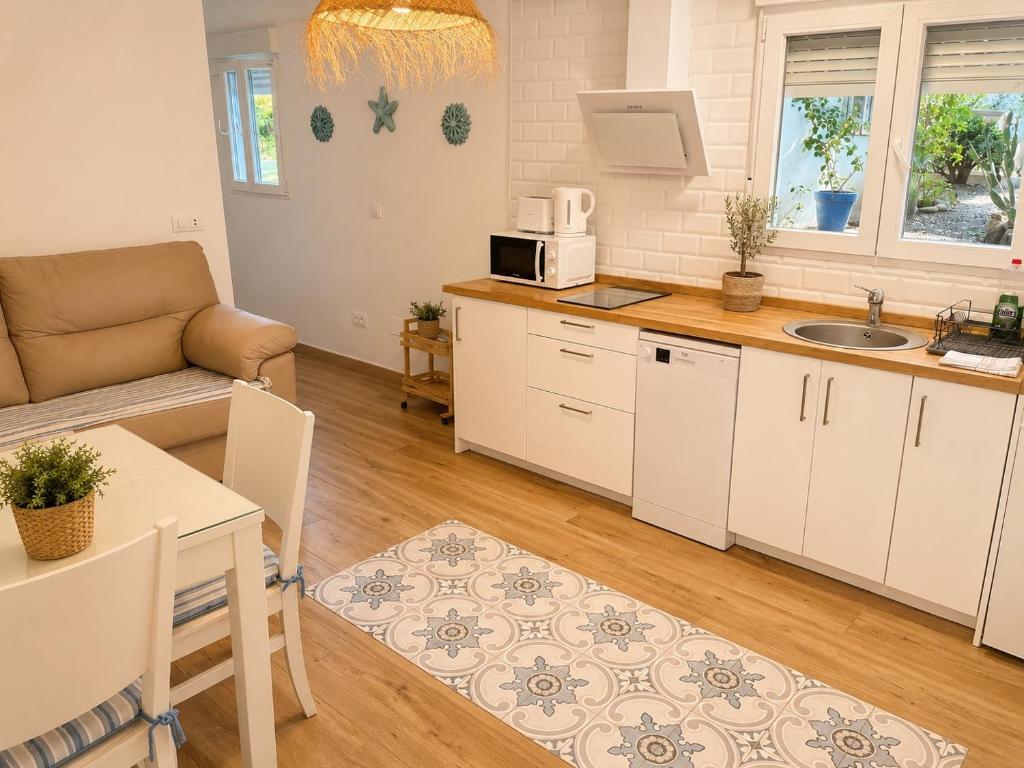 a kitchen and living room with a couch and a table at DUNA - Escapada romántica en Punta Paloma in Tarifa