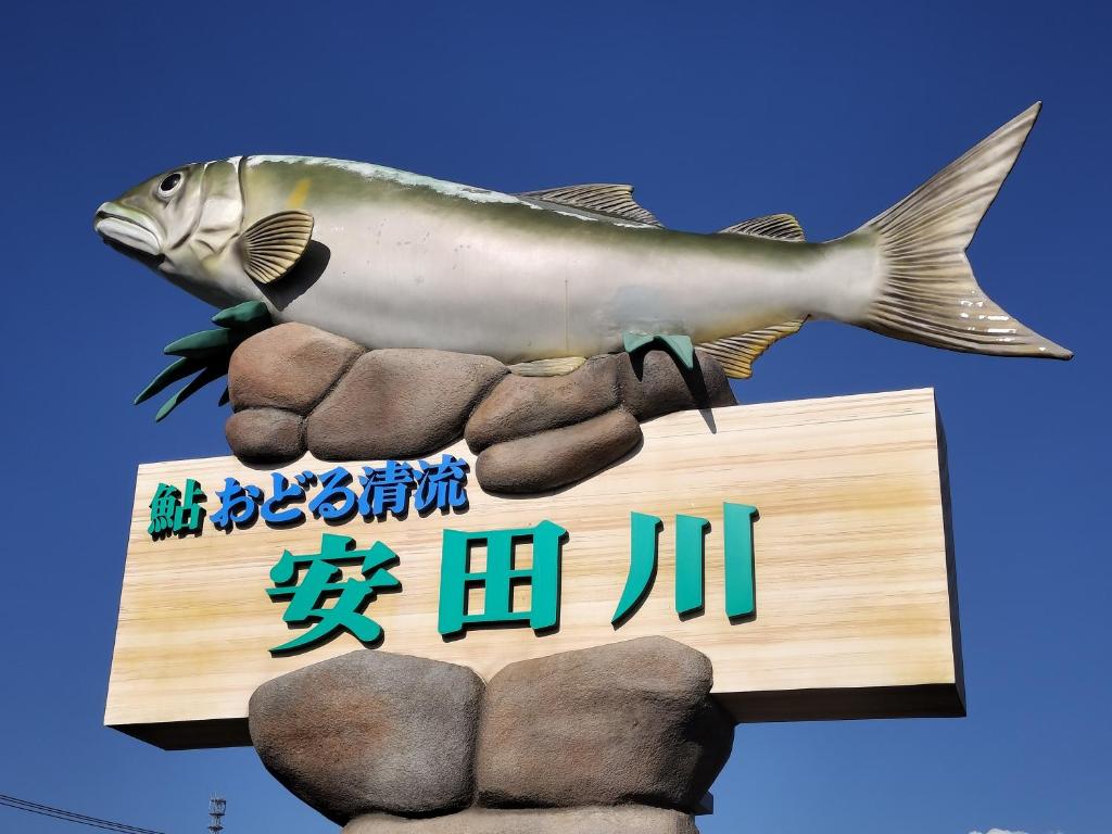 a sign for a restaurant with a fish on it at 民宿 とうの浜 in Yasuda